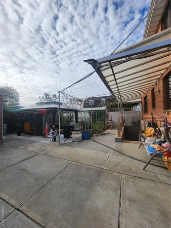a view of a patio with table and chairs under an umbrella