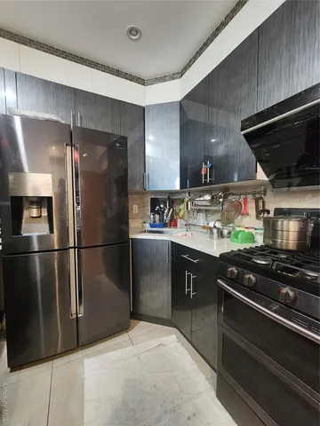 a kitchen with stainless steel appliances a refrigerator and a stove top oven