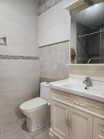 a bathroom with a sink a toilet and mirror