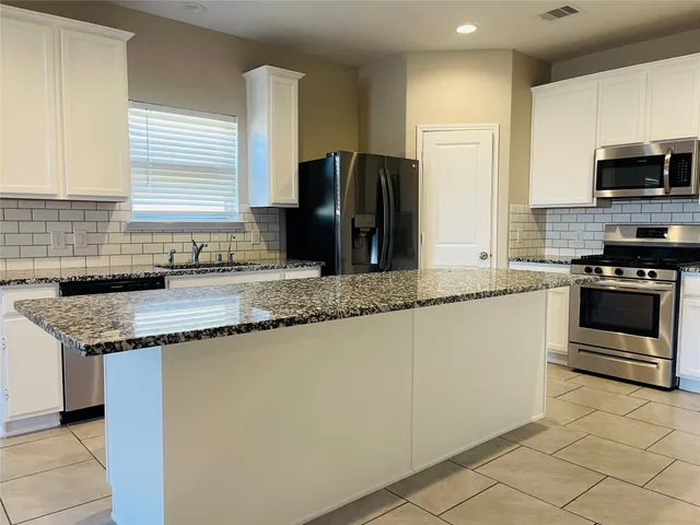 a kitchen with stainless steel appliances granite countertop a sink and a stove