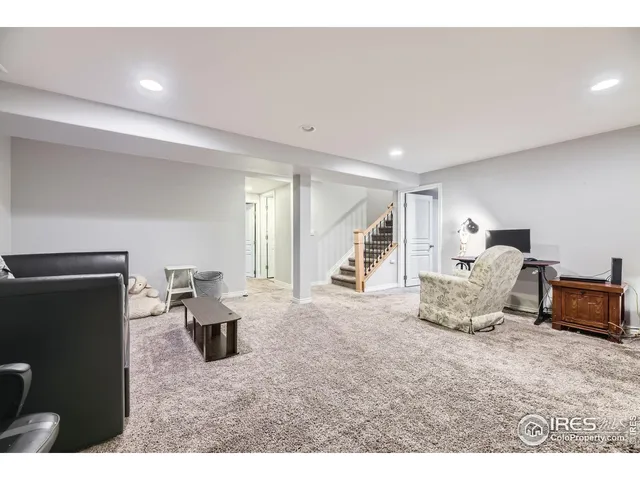 a bedroom with a bed a large window and dresser