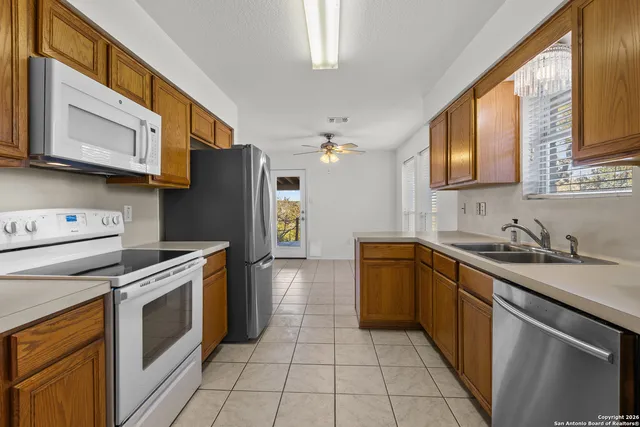a kitchen with stainless steel appliances granite countertop a stove a sink and a microwave