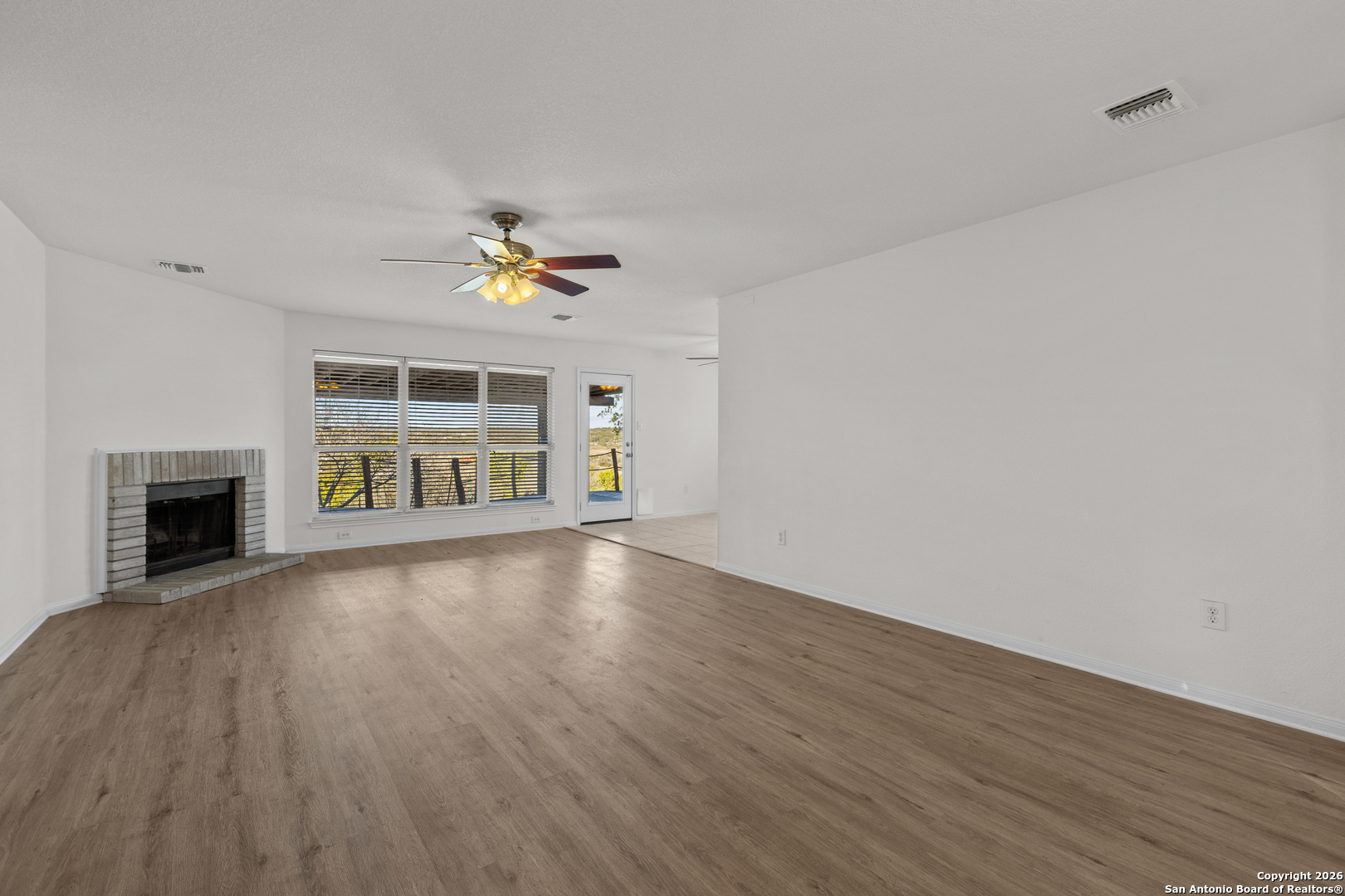 431 Windy Hill Drive Spring Branch, TX 78070 - Photo 8 of 45 wooden floor in an empty room with a window