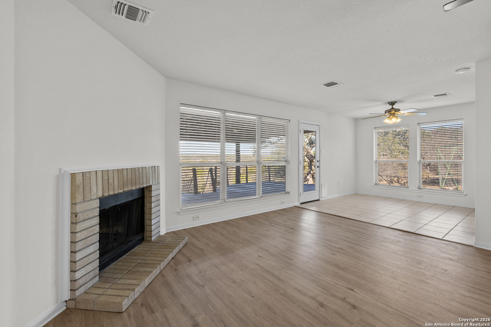 431 Windy Hill Drive Spring Branch, TX 78070 - Photo 10 of 45 an empty room with floor to ceiling window and wooden floor