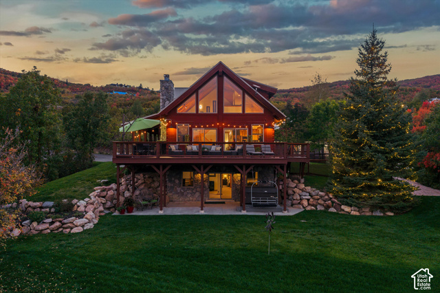 5878 Snowbasin Road Huntsville, UT 84317 - Photo 86 of 90 A-frame structure with expansive glass, multi-level decking, stone foundation, and a landscaped rock wall