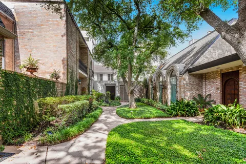 a view of a white house next to a yard