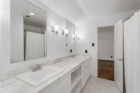 a spacious bathroom with a granite countertop double vanity sink mirror and bathtub