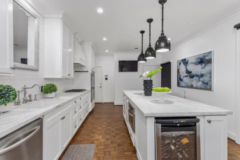 a kitchen with stainless steel appliances granite countertop a stove a sink and a refrigerator