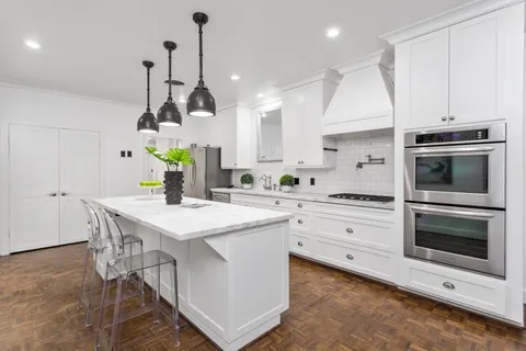a kitchen with a stove cabinets and wooden floor