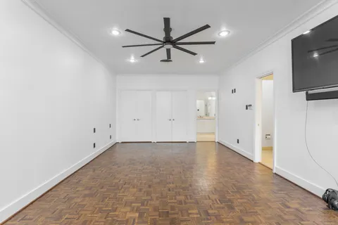 an empty room with closet and a ceiling fan