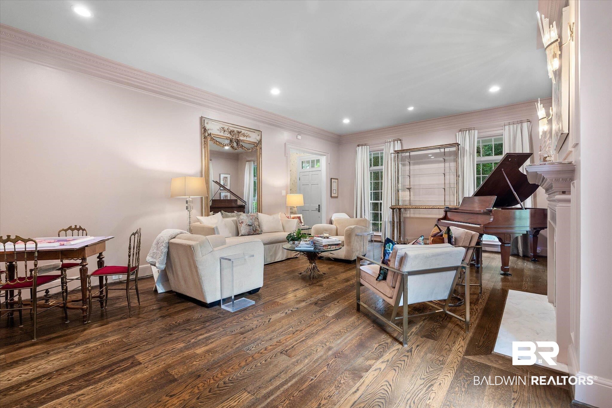 3908 Yester Place Mobile, AL 36608 - Photo 9 of 45 Spacious living area featuring rich wood-finish flooring, recessed lighting, architectural crown molding, multiple windows with natural light, and a fireplace with a stone hearth