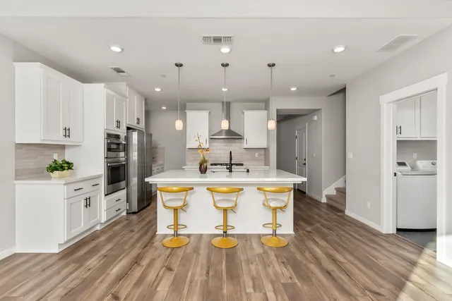 a view of a kitchen with kitchen island and stainless steel appliances