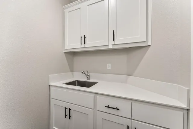 a kitchen with white cabinets and a sink