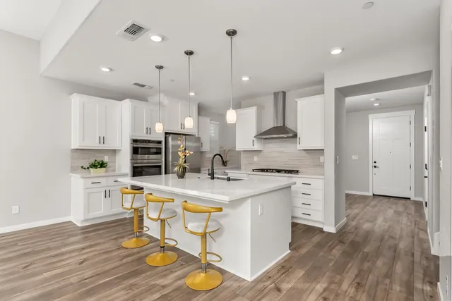 a kitchen with kitchen island a stove a table and chairs in it