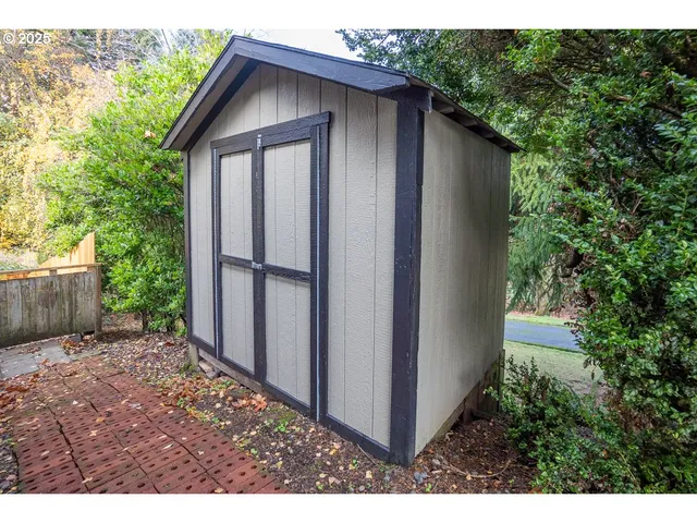 a view of backyard of house with wooden fence
