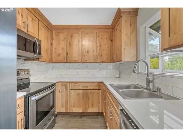 a kitchen with stainless steel appliances granite countertop a sink stove and microwave