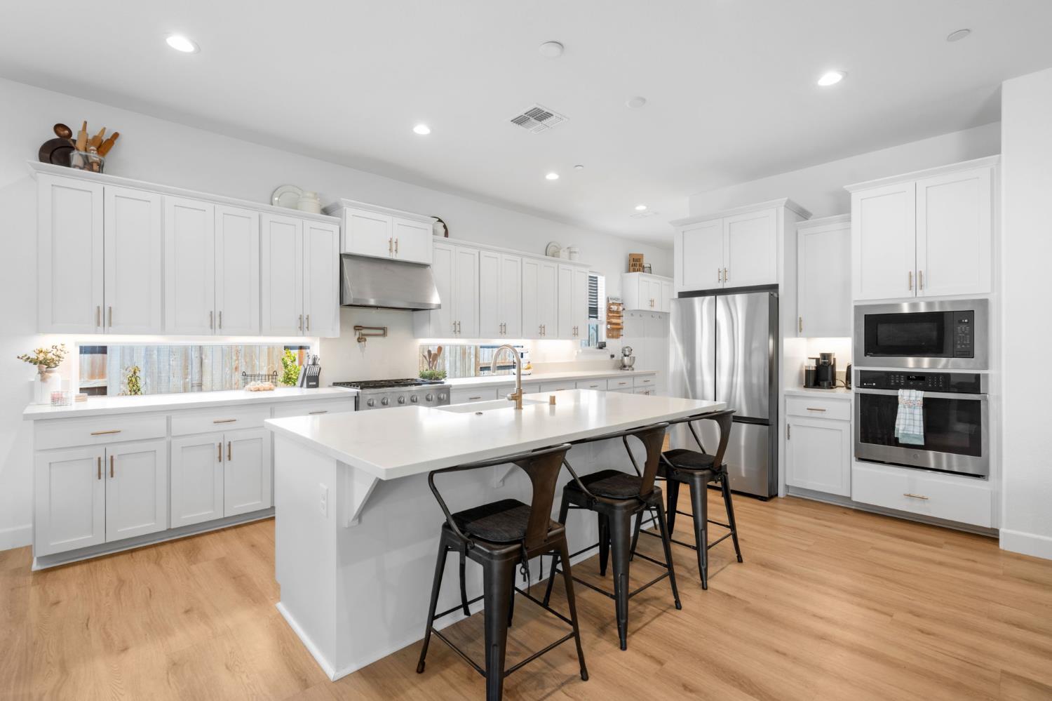 4314 Moro Cyn Street Rancho Cordova, CA 95742 - Photo 11 of 39 a kitchen with a sink a microwave a refrigerator and white cabinets