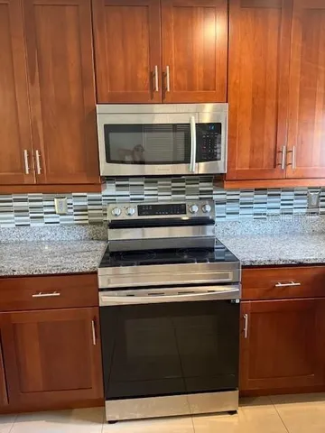 a kitchen with wooden cabinets and a stove top oven