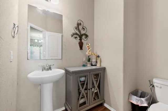 a bathroom with a sink a toilet and mirror