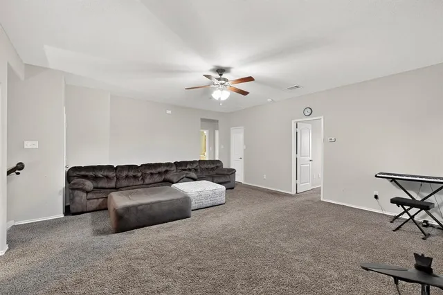 a living room with furniture and a ceiling fan
