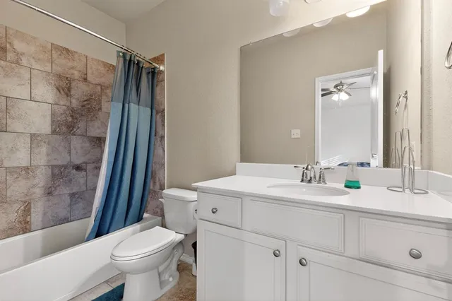 a bathroom with a sink a toilet a mirror and shower