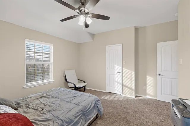 a bedroom with a large bed and wooden floor