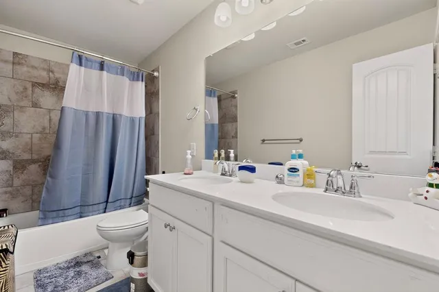 a bathroom with a double vanity sink toilet and shower
