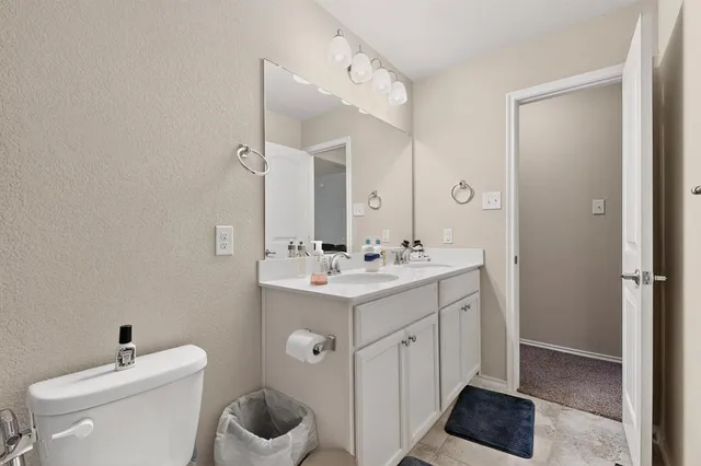 a bathroom with a toilet sink and mirror