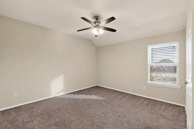 an empty room with window and ceiling fan
