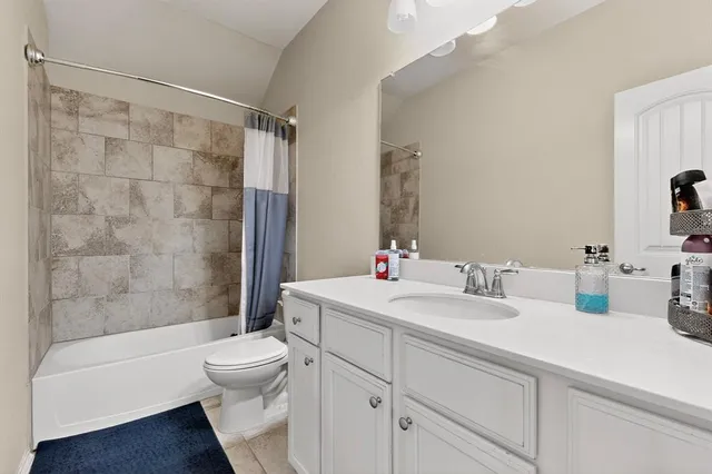 a bathroom with a bathtub shower sink mirror vanity and toilet