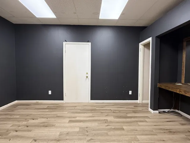 a view of a livingroom with wooden floor and bathroom