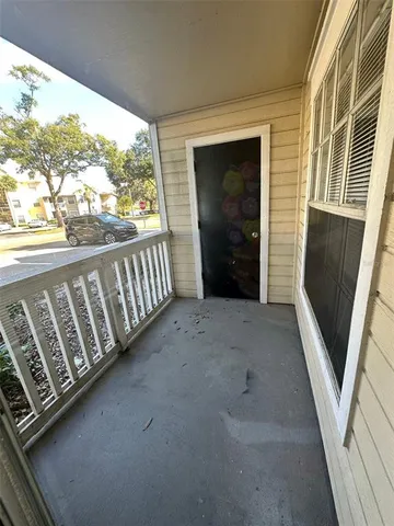 a view of a porch with wooden floor in front of a house