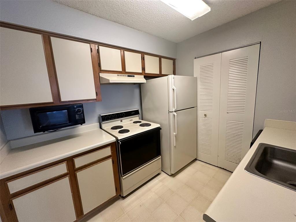 1063 South Hiawassee Road, Unit 1613 Orlando, FL 32835 - Photo 8 of 13 a kitchen with stainless steel appliances a refrigerator a sink and a stove