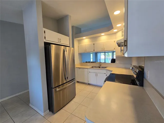 a kitchen with a refrigerator sink and cabinets