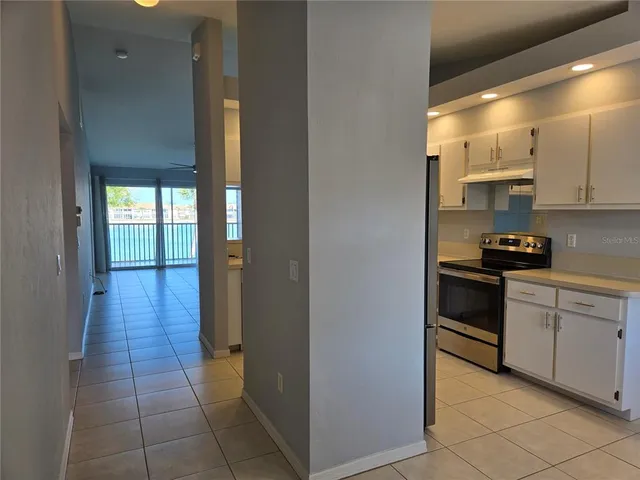 a kitchen with a refrigerator and white cabinets