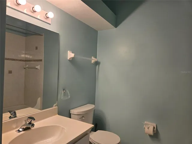 a bathroom with a sink a toilet and mirror