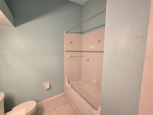 a bathroom with a granite countertop bathtub and toilet
