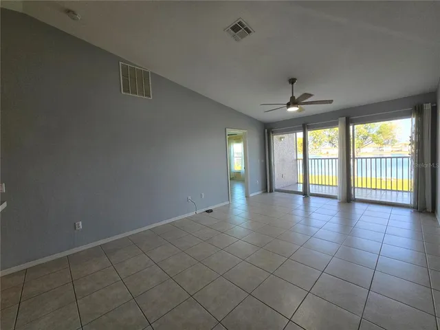 an empty room with windows and chandelier