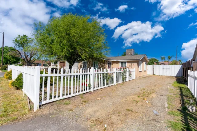a view of a house with backyard and a tree