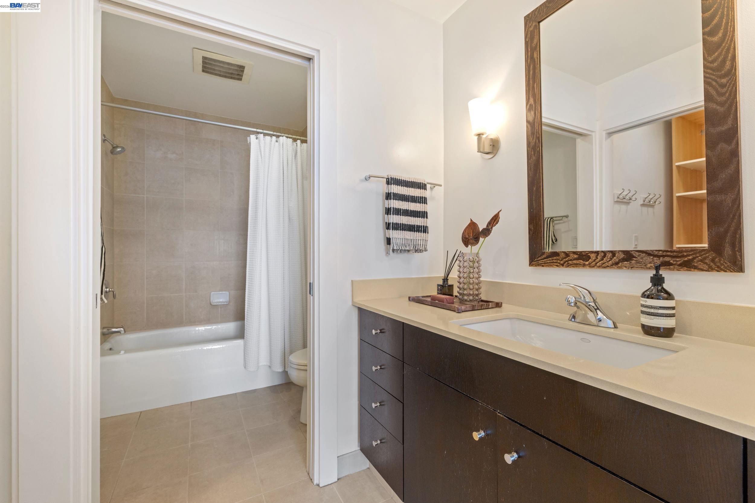 585 Ninth Street, Unit 443 Oakland, CA 94607 - Photo 11 of 32 a bathroom with a double vanity sink mirror and shower