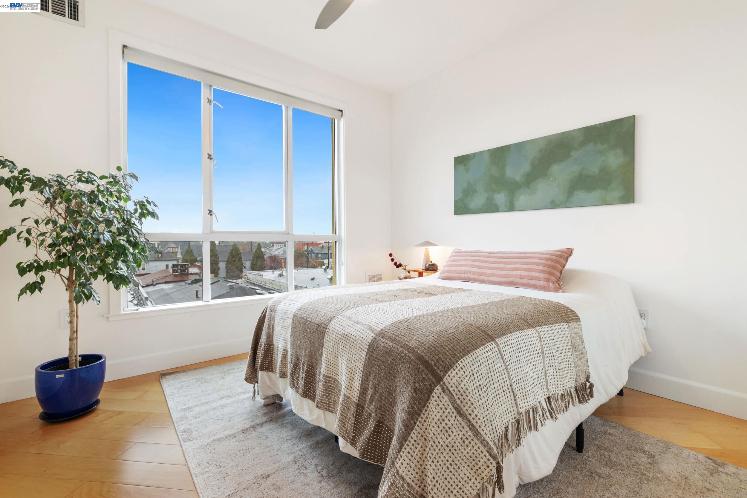 585 Ninth Street, Unit 443 Oakland, CA 94607 - Photo 13 of 32 a bedroom with a bed and a potted plant