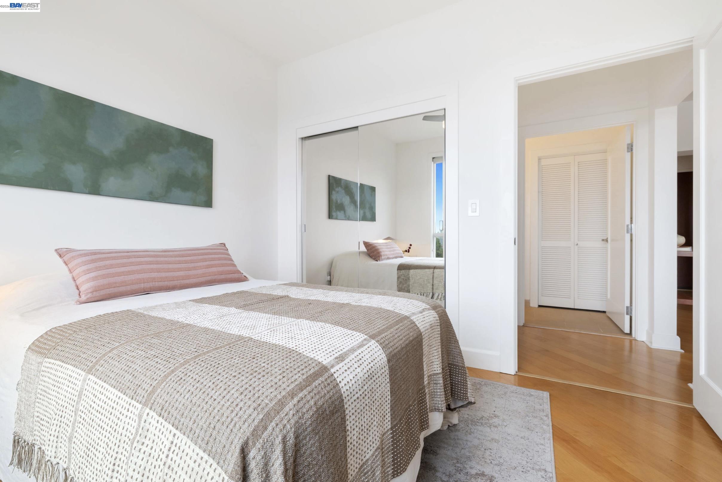 585 Ninth Street, Unit 443 Oakland, CA 94607 - Photo 14 of 32 a bedroom with a bed and a mirror