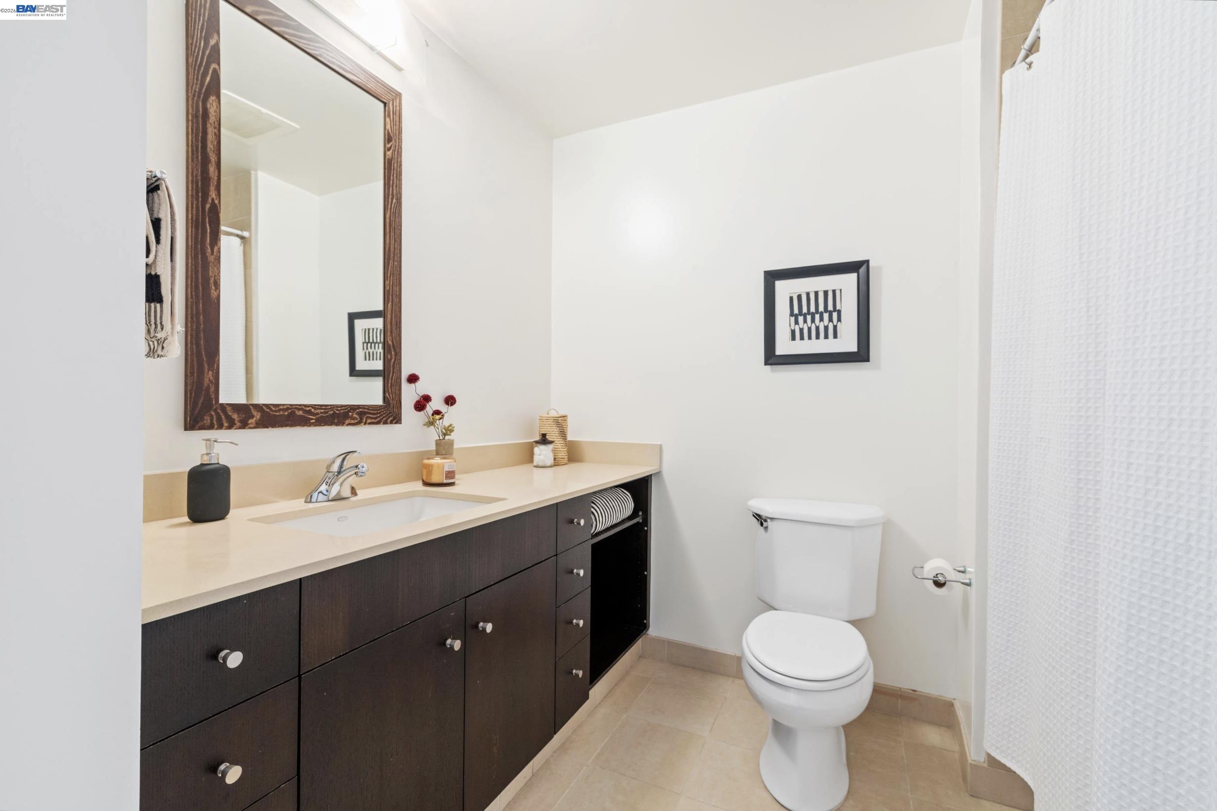 585 Ninth Street, Unit 443 Oakland, CA 94607 - Photo 17 of 32 a bathroom with a toilet sink and mirror