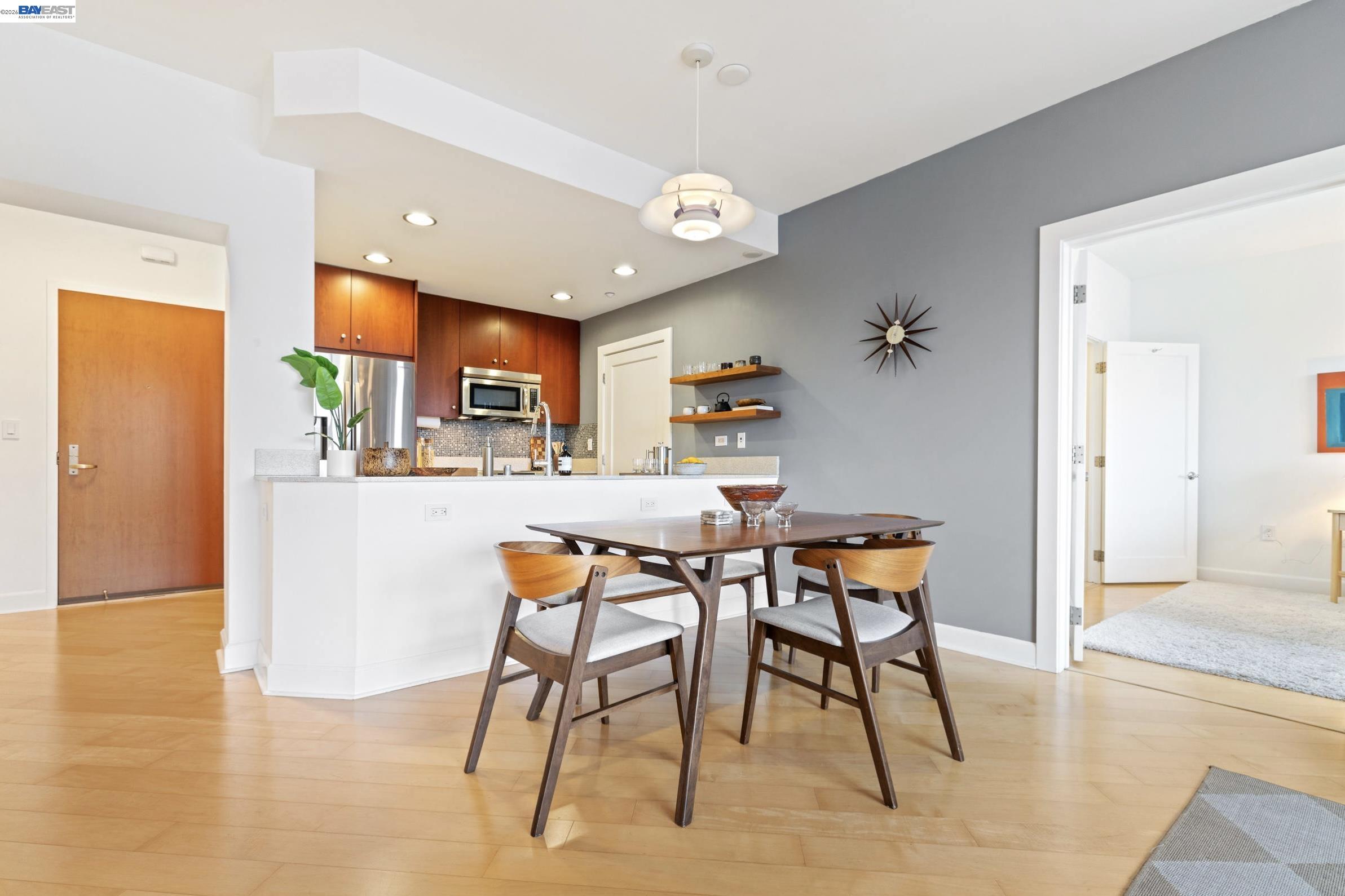 585 Ninth Street, Unit 443 Oakland, CA 94607 - Photo 4 of 32 a kitchen with stainless steel appliances kitchen island granite countertop dining table chairs and a refrigerator