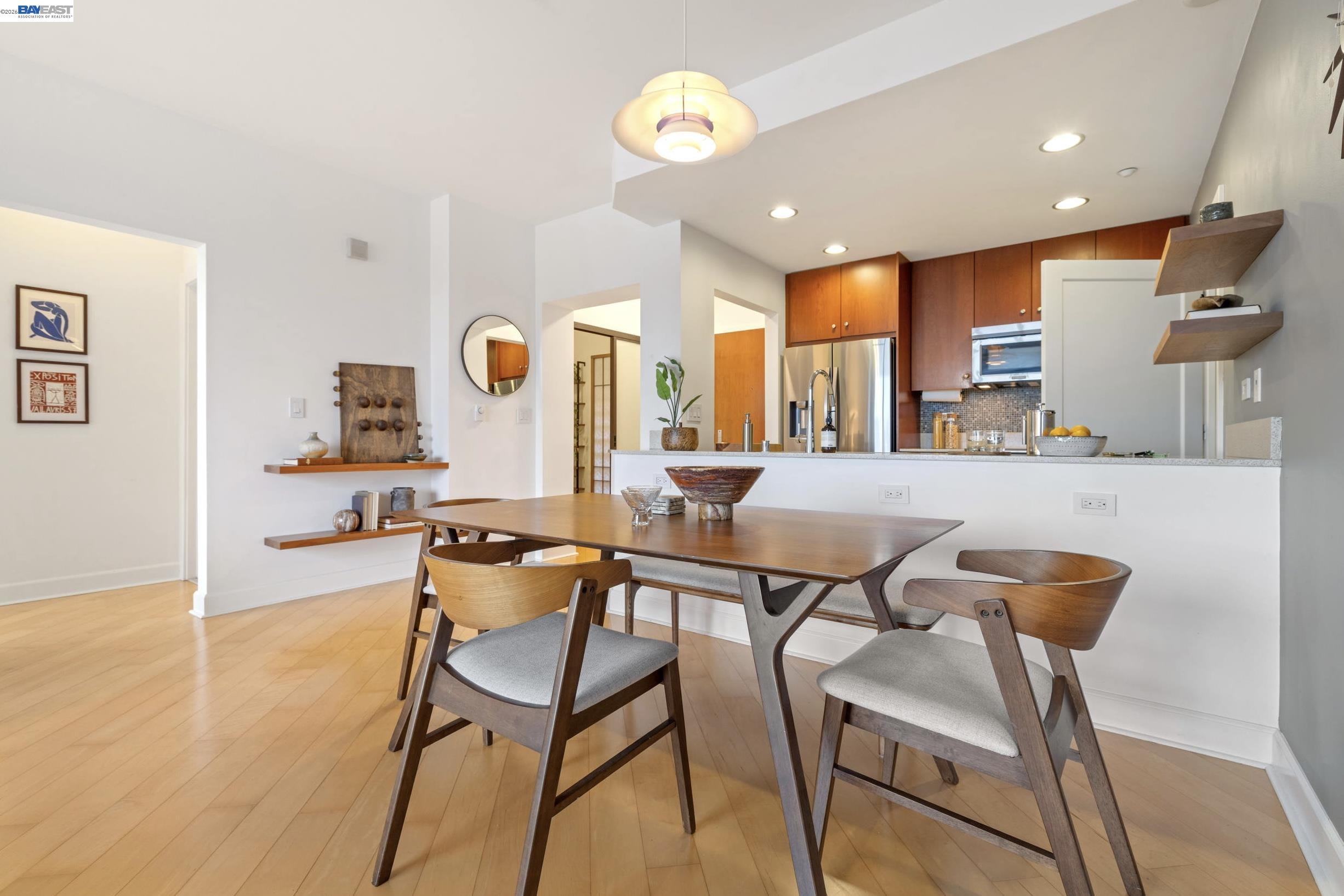 585 Ninth Street, Unit 443 Oakland, CA 94607 - Photo 5 of 32 a dining hall with stainless steel appliances a dining table and chairs with wooden floor