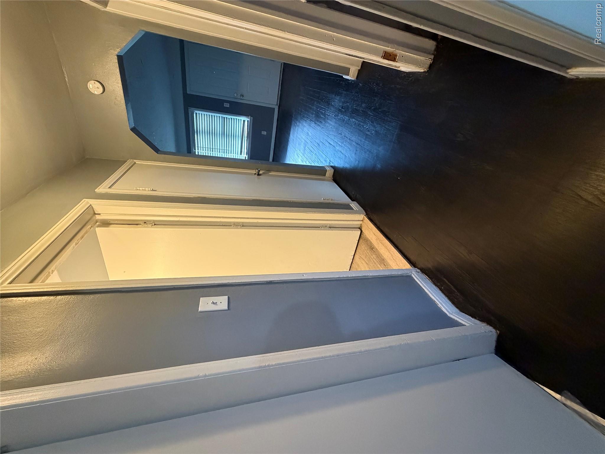 7633 Fielding Street Detroit, MI 48228 - Photo 9 of 12 Dark wood-finish flooring throughout, complemented by a light gray wall color and white trim