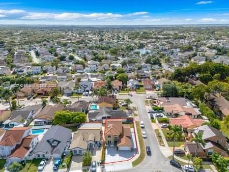an aerial view of a city with lots of residential buildings and mountain view in back
