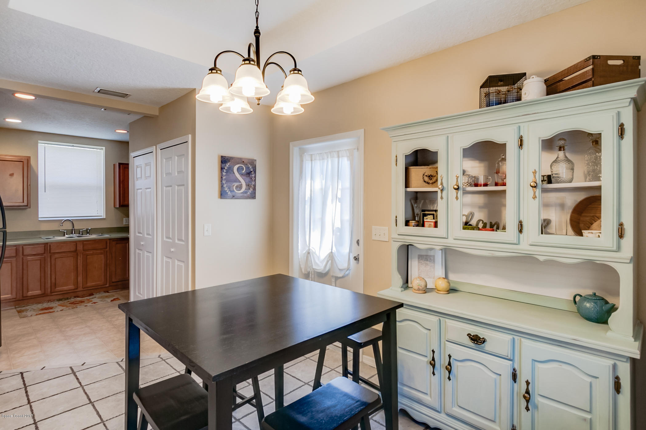 4670 Ashbury Road Cocoa, FL 32927 - Photo 14 of 29 a kitchen with a table chairs refrigerator and cabinets