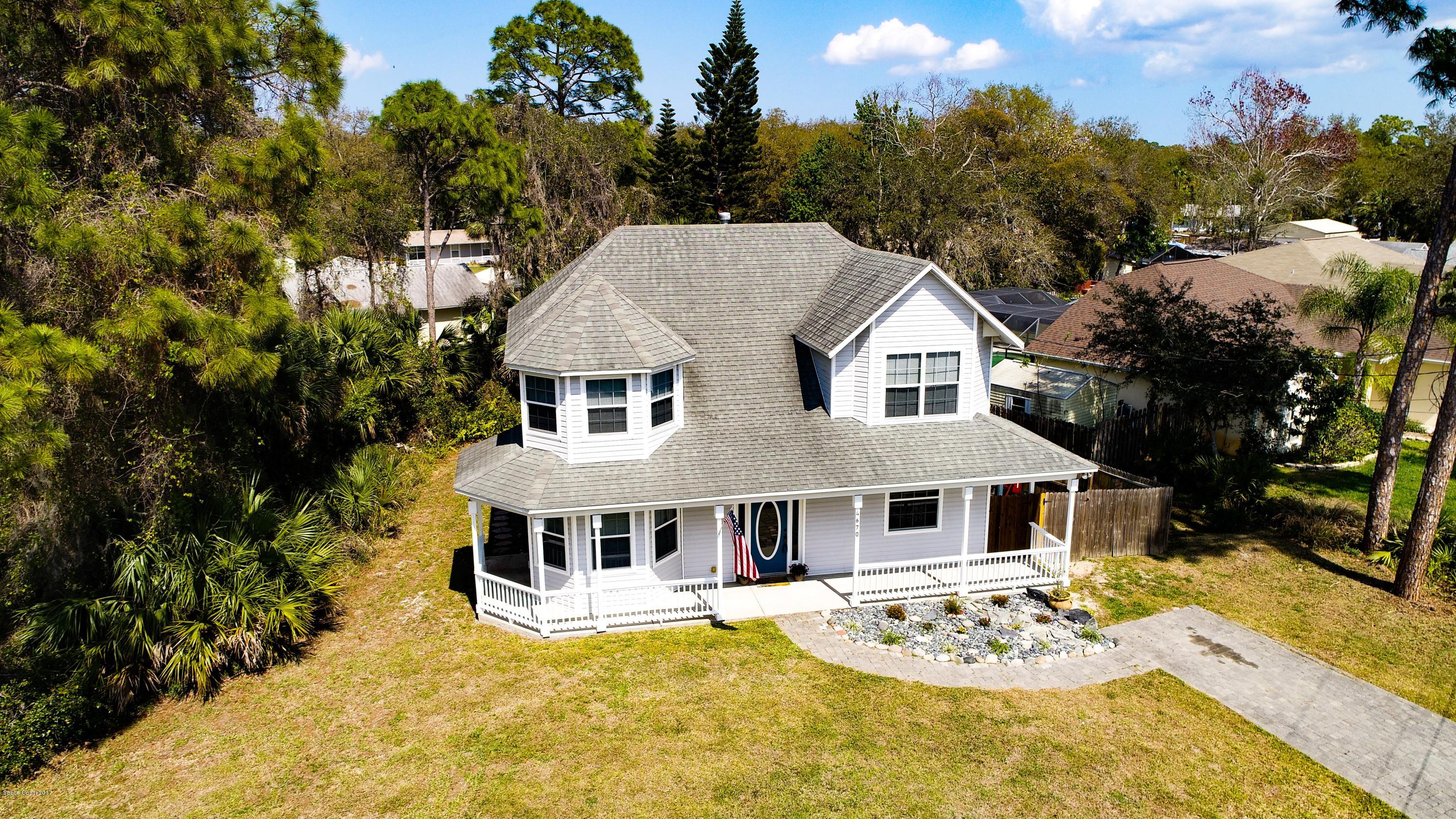4670 Ashbury Road Cocoa, FL 32927 - Photo 3 of 29 a view of a white house with a large pool and a yard