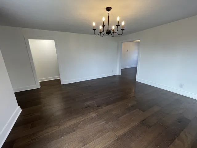a view of a chandelier in big room with wooden floor